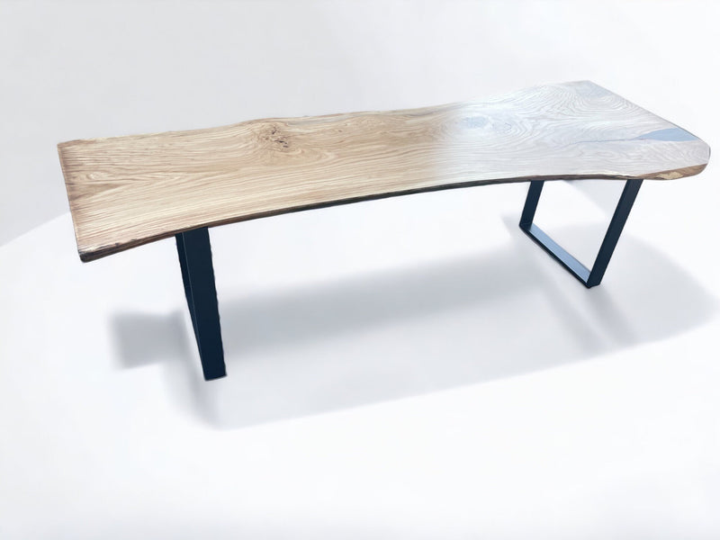 Artisan oak wood slab dining table with natural contours and industrial metal support legs
