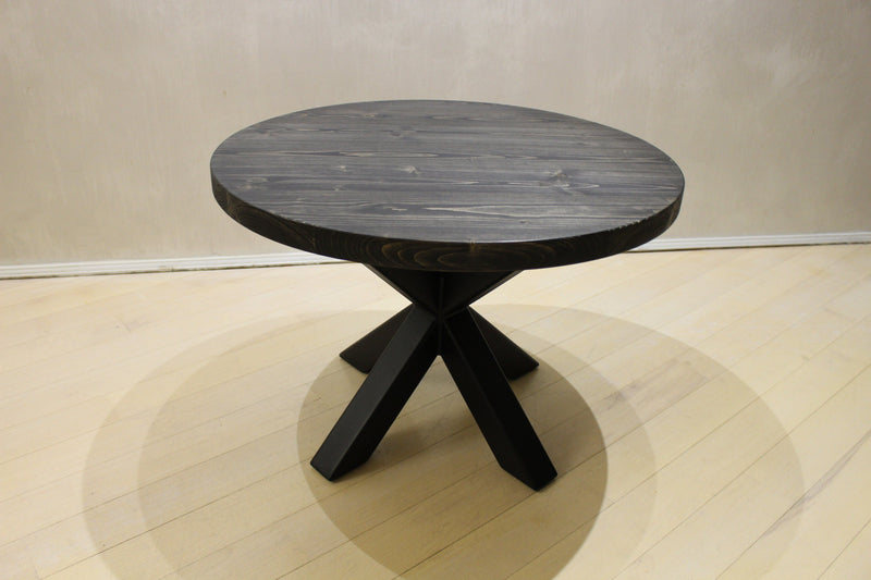 Black solid wood coffee table with round top and bold black spider legs, ideal for living rooms and lounges