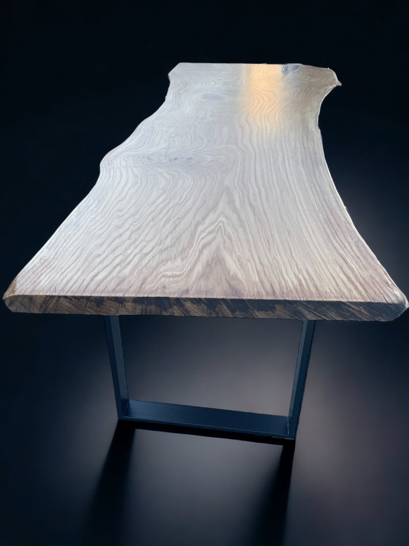 Custom-made live edge dining table in solid oak with sculptural black steel legs – unique monolithic design