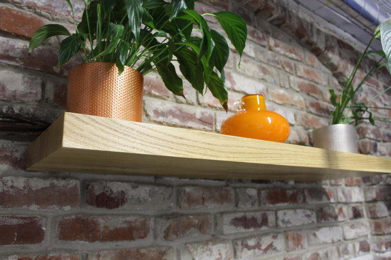 Custom-made oak floating shelves with natural wood grain, modern shelving for living room décor