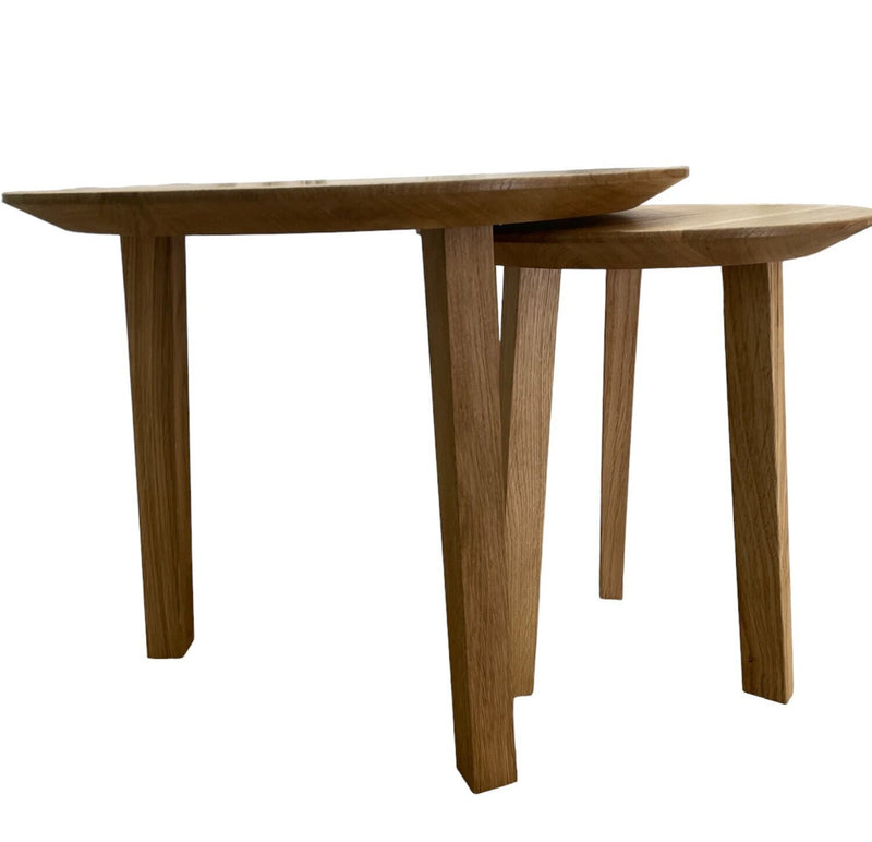 Handcrafted oak nesting coffee tables with round tops, designed for flexible and functional living room setups