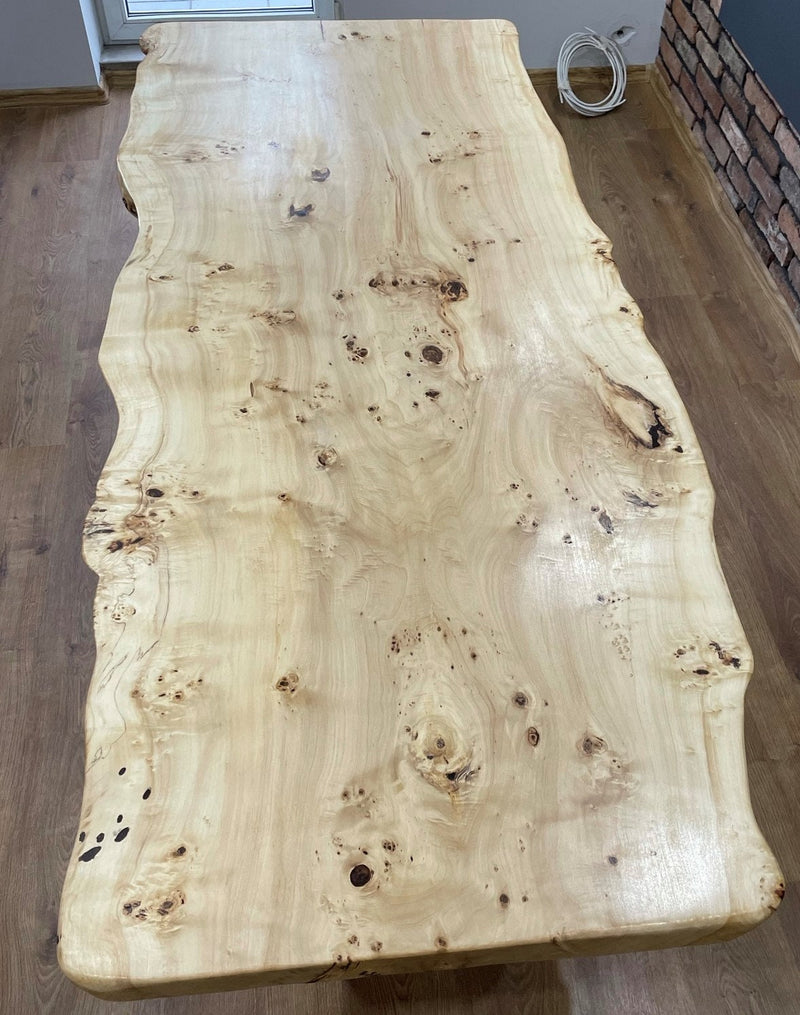 Handcrafted live edge oak monolith table with sculptural white U-shaped metal legs