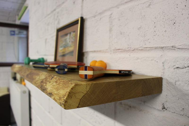 Rustic solid oak floating shelf with natural edge profile, perfect for contemporary wall storage solutions