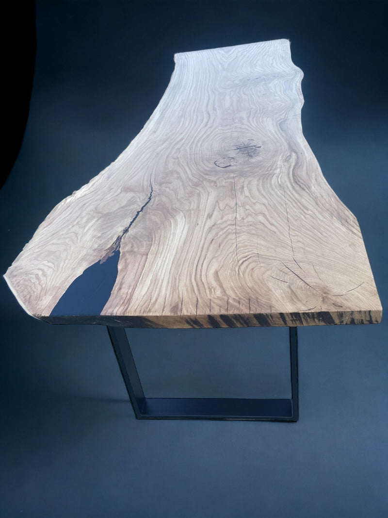 Large solid wood dining table made from a single oak slab with live edge and heavy-duty metal frame