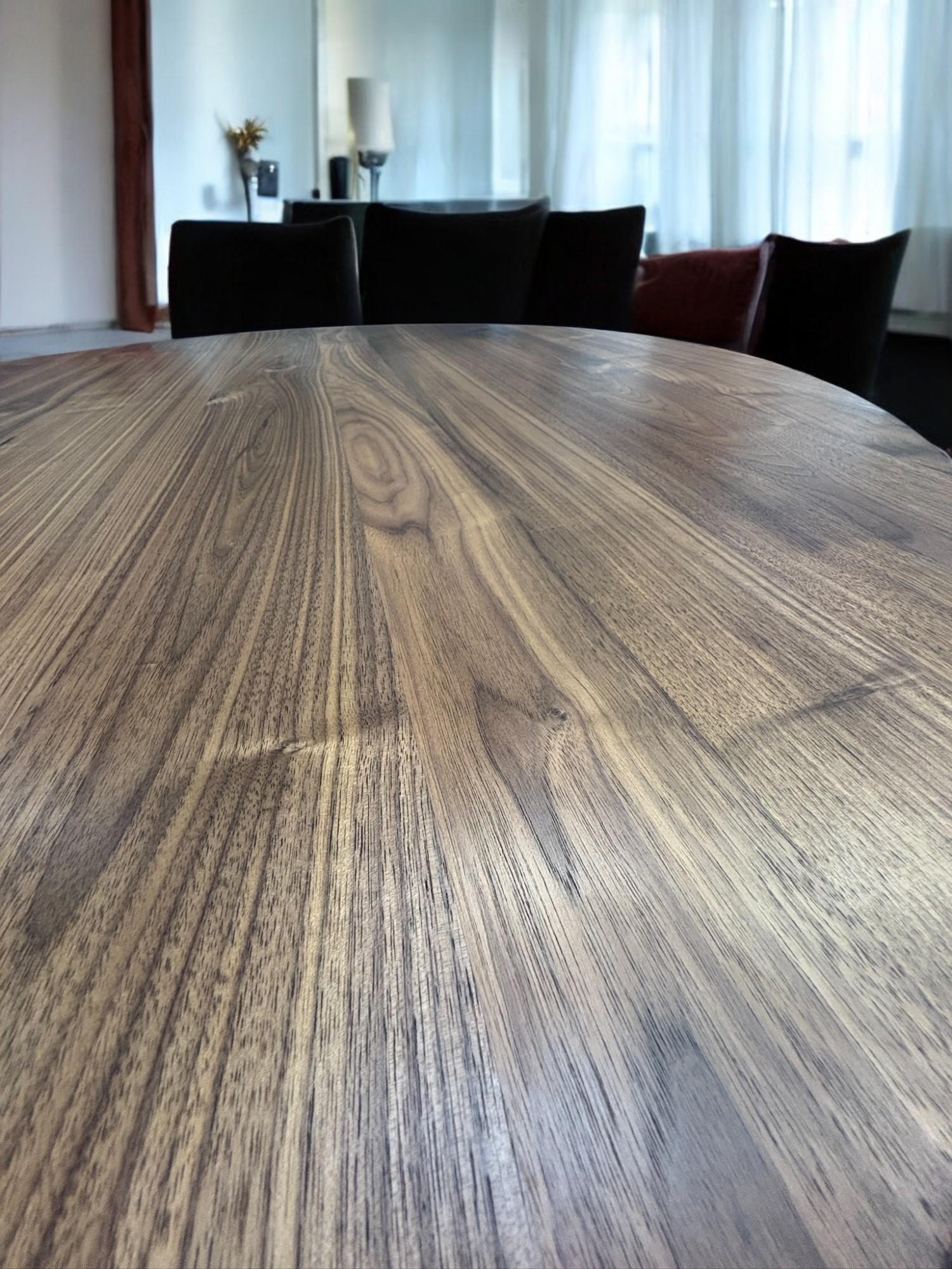 Elegant American walnut dining table with round expandable top and central iron base