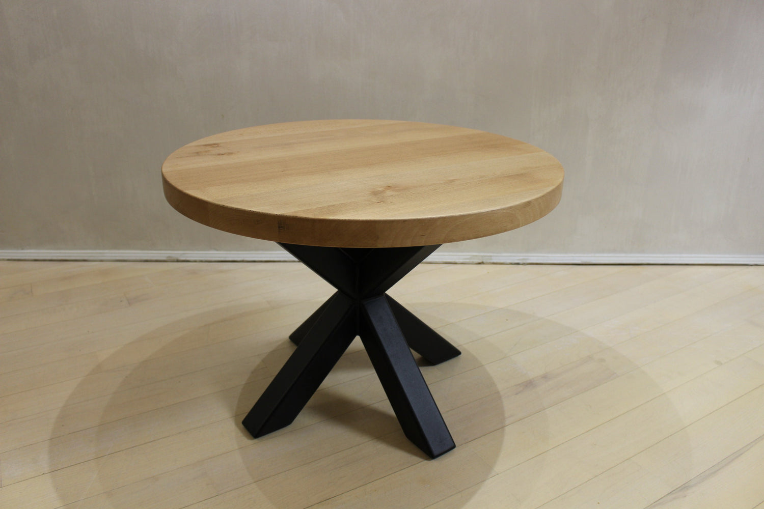 Loft-style coffee table with round oak top and spider-shaped metal legs, handcrafted designer piece