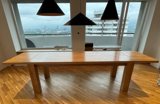Mammouth oakwood dining table with extendable top and sturdy wooden legs, ideal for gatherings of 6 to 12 people