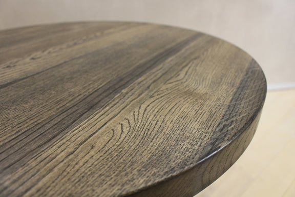 Minimalist round coffee table in natural wood finish with industrial style black spider legs