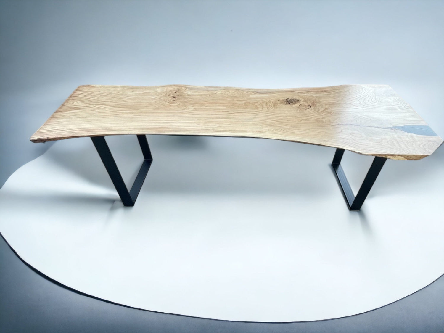 Handcrafted solid oak monolith table with live edge top and U-shaped metal base, bespoke dining furniture