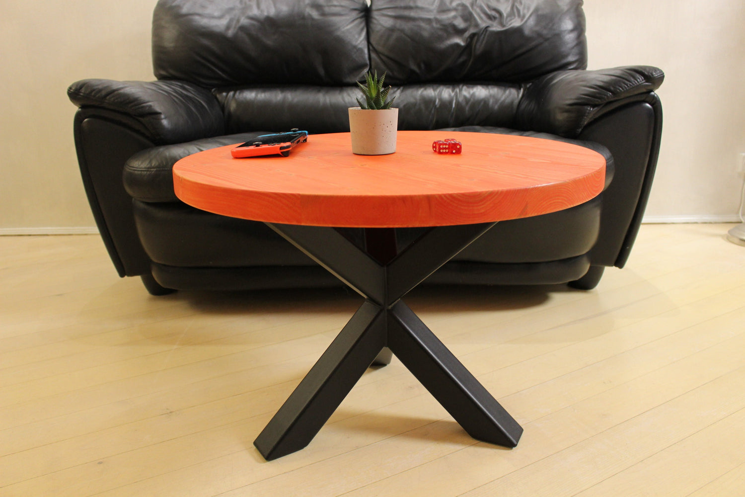 Red modern round coffee table combining solid wood craftsmanship with industrial black metal legs